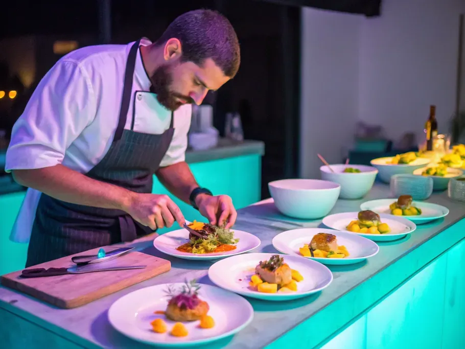 Professional chef meticulously plating dishes in a modern kitchen setting