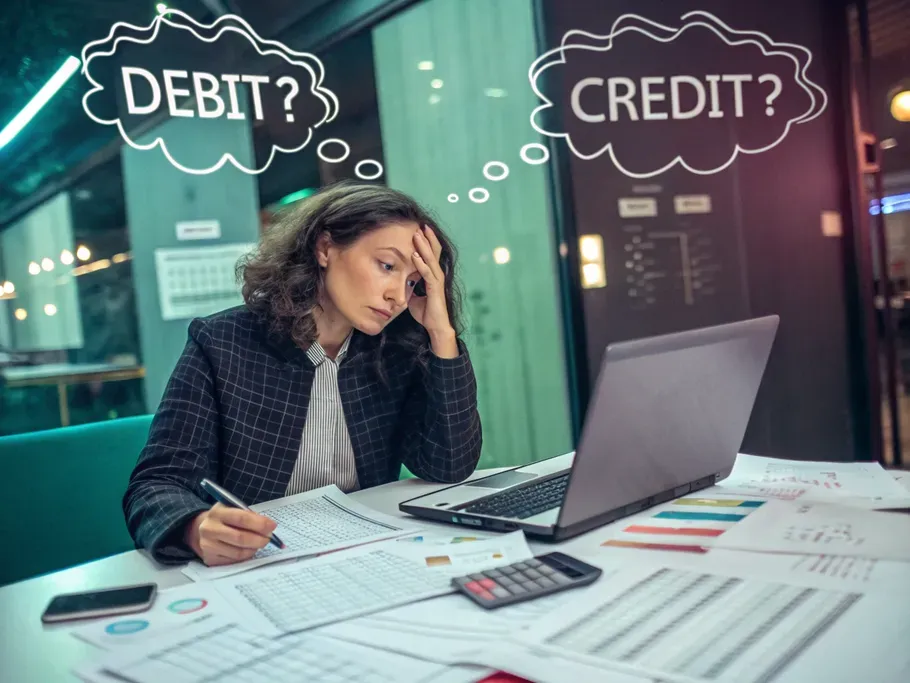 Young female tech startup founder overwhelmed by financial reports, pondering debit and credit.