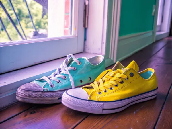 Two pairs of sneakers, one old and faded, the other vibrant and new, illustrating depreciation in assets